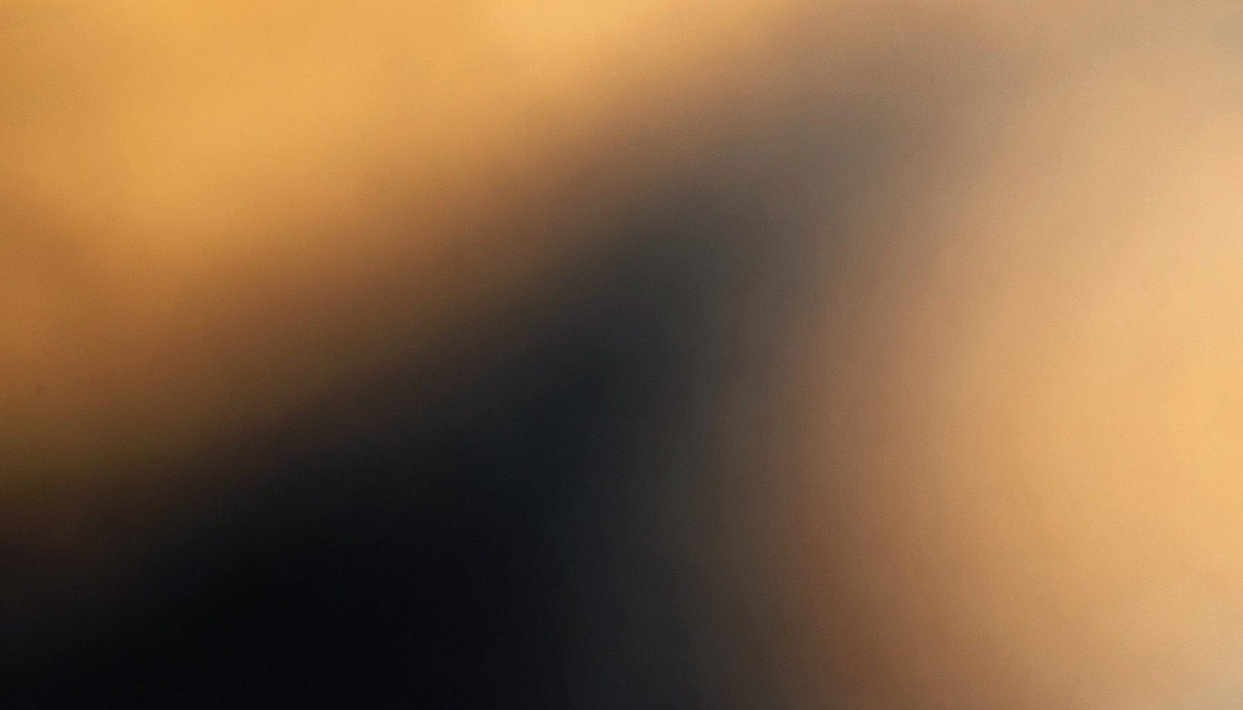 Warm-toned abstract composition with soft amber and deep charcoal gradients, evoking a calm and reflective everyday atmosphere